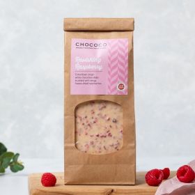White Chocolate Ravishing Raspberry Slabs by Chococo on a chopping board with pale pink linen napkin and fresh raspberries. 