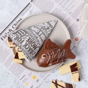 A novelty chocolate fish & chips made from milk & white chocolate by Chococo with newspaper place mat  