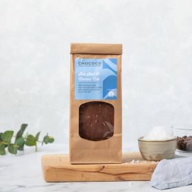 Milk Chocolate Sea Salt & Cocoa Nib Slabs by Chococo on top of wooden chopping with linen napkin and small posts of sea salt and nibs 