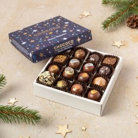a box of 16 handcrafted luxury festive Christmas chocolates in their box with Xmas trees and pine cones around it 