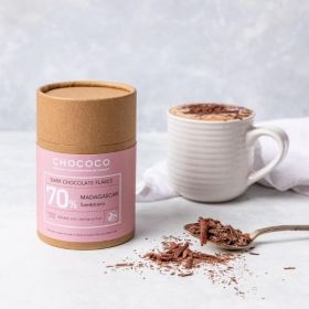 a kraft tube of hot-chocolate flakes by Chococ with full mug of Chocolate 