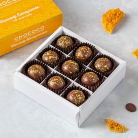 Honeycombe handcrafted milk chocolates by Chococo in chocolate box with scattered pieces around 
