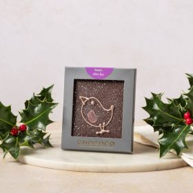 Dark chocolate mini bar by Chococo with hand-piped robin design on. Packaged in a grey box sat next to fresh real holly with red berries on 