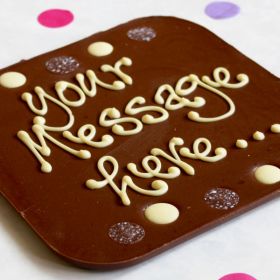 A Chococo giant milk chocolate bar where you can write a personalised message on surrounded by buttons. proudly handcrafted in Dorset 