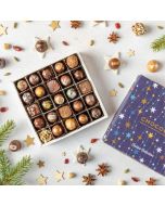a top down view of a festive collection chocolate box by chococo with star anise, cloves and cardamon scattered about 