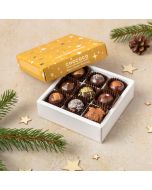 a small box of 9 handcrafted vegan dark handcrafted festive chocolates by Chococo with yellow gold star lid with wooden stars scattered around 