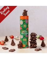 Dark Chocolate festive shapes in a tube by Chococo with snowmen, Santas and tree shapes with glass baubles scattered around tube. 